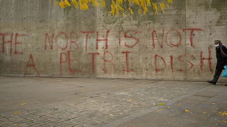 A masked man holds the last graffiti in central Manchester