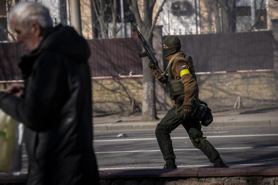 A Ukrainian soldier holds his pistol near a military facility in Kiev.