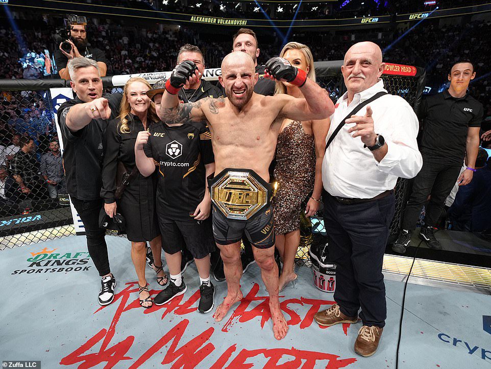 The champion stood with his team and family in the octagon after beating Holloway for the third time