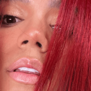 Carol G casts a web covering herself only with her red hair